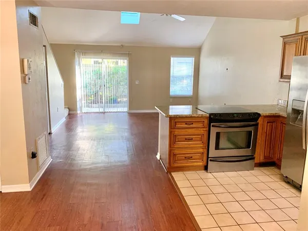 a kitchen with stainless steel appliances kitchen island wooden floors and stove