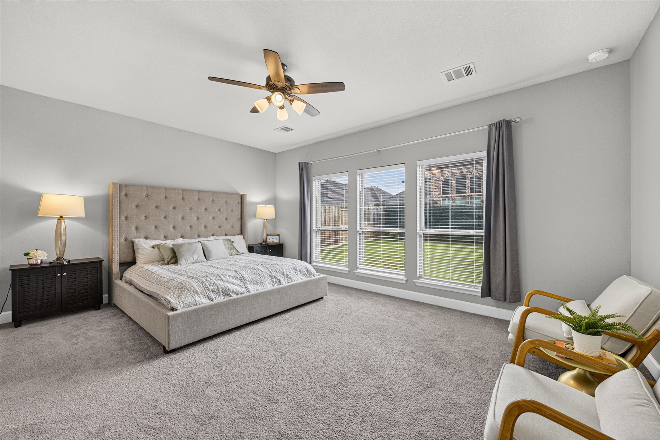 4207 Ana Ridge Lane Fulshear, TX 77441 - Photo 15 of 37 Serene primary suite showcasing wide windows and plush carpet, designed for restful nights and ultimate relaxation.