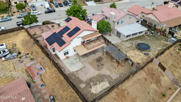 a aerial view of a house with a yard and large tree