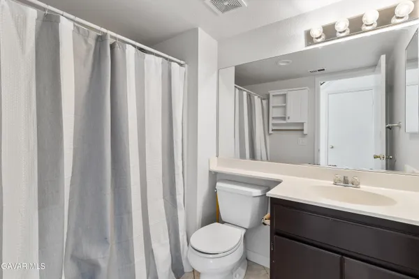 a bathroom with a sink a toilet a mirror and shower