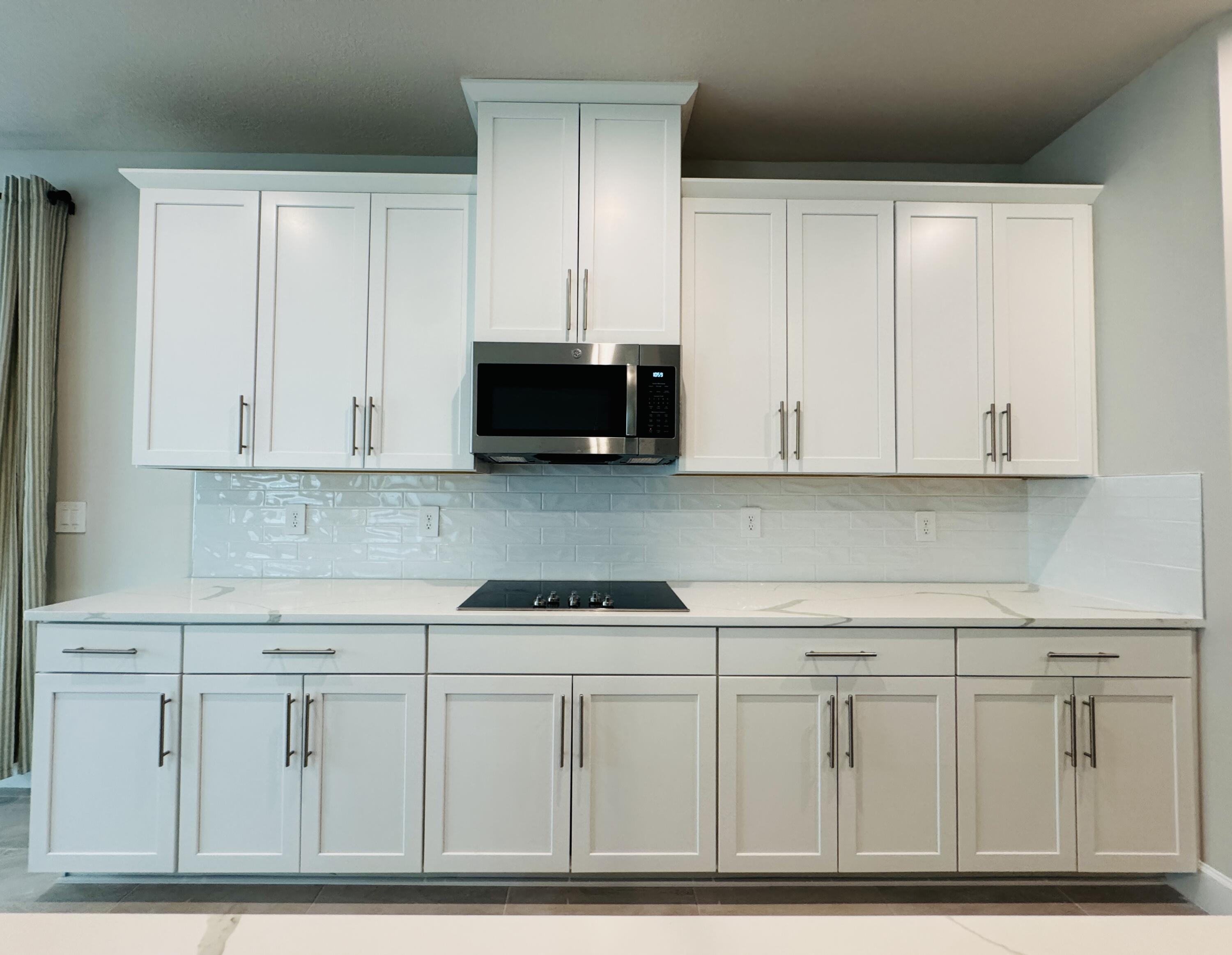 163 Southwest Pomeroy Street Stuart, FL 34997 - Photo 12 of 52 a kitchen with white cabinets and sink