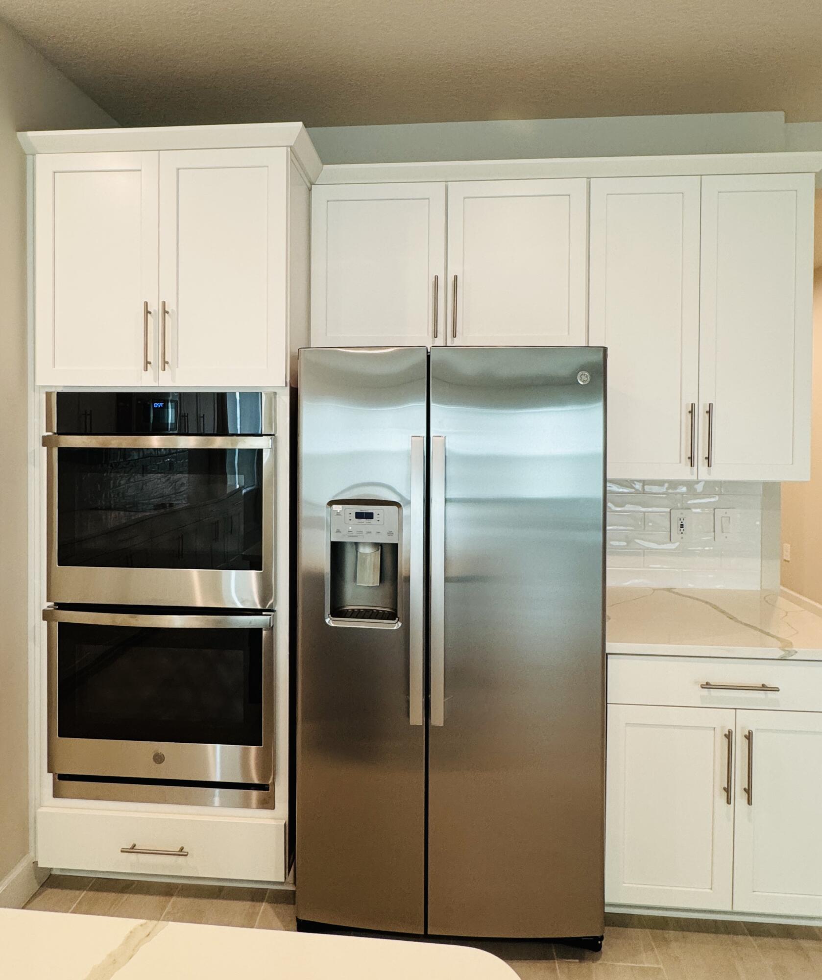 163 Southwest Pomeroy Street Stuart, FL 34997 - Photo 15 of 52 a kitchen with a refrigerator and white cabinets