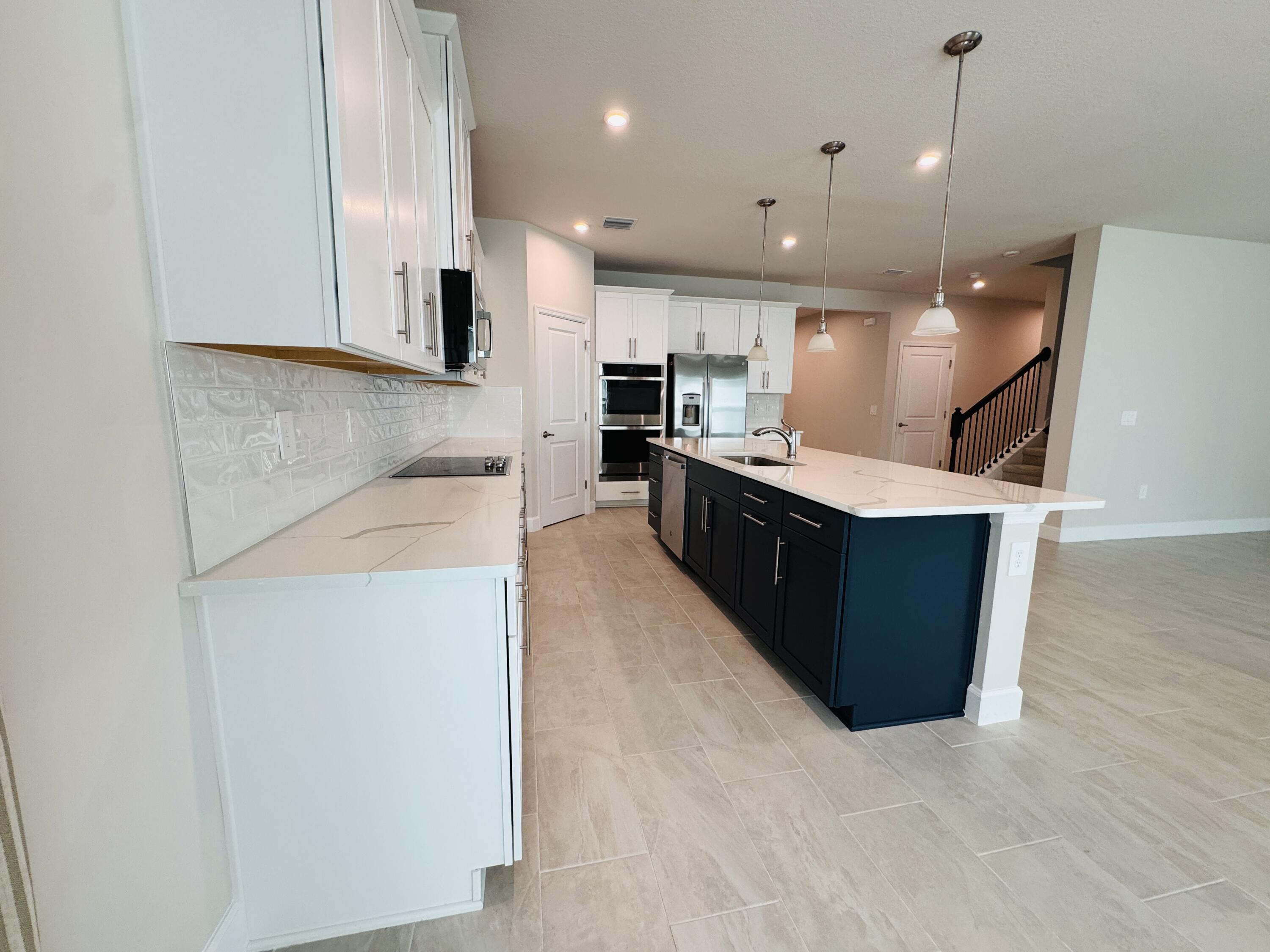 163 Southwest Pomeroy Street Stuart, FL 34997 - Photo 17 of 52 a large kitchen with kitchen island a sink stainless steel appliances and cabinets