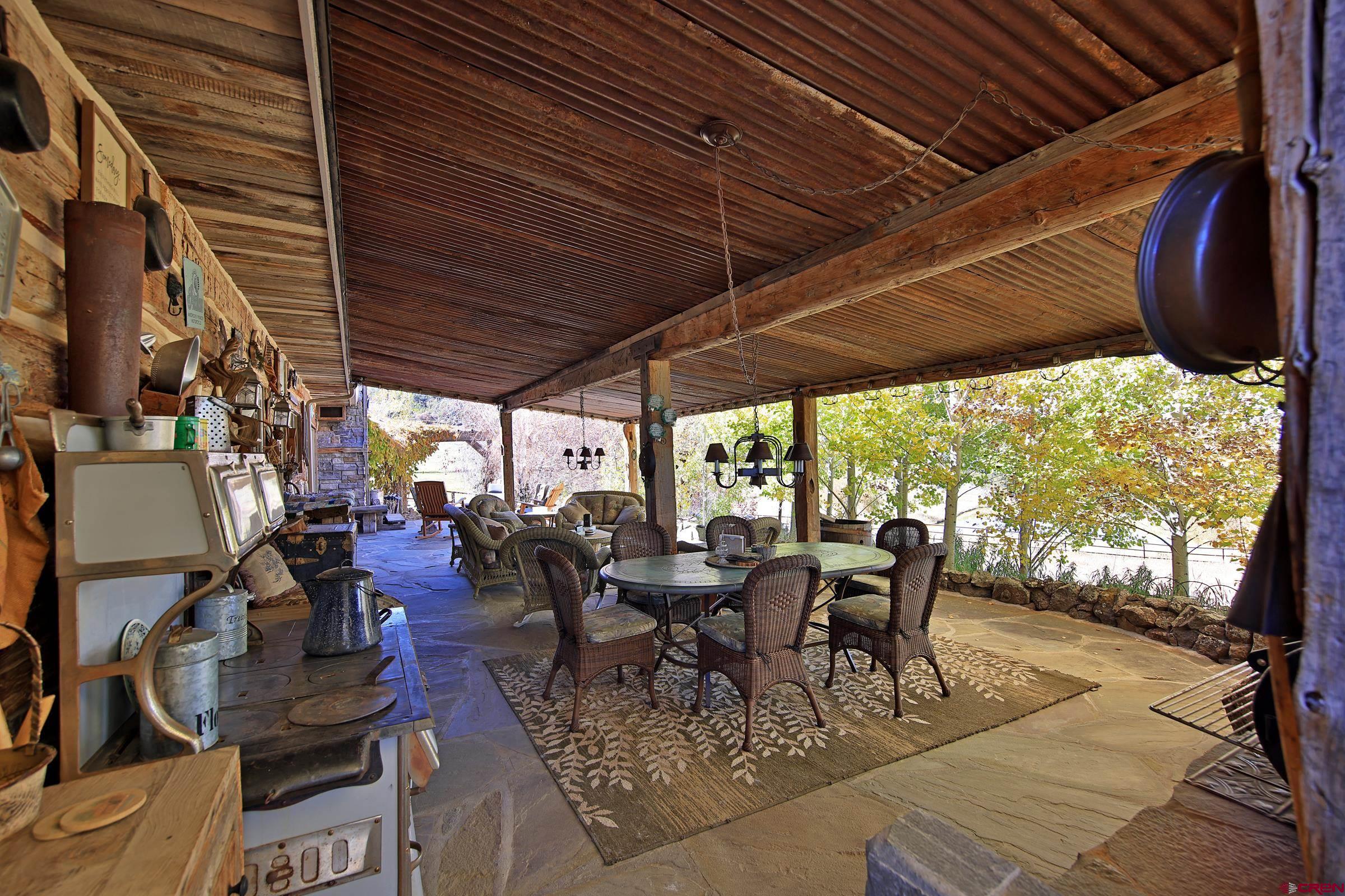 10497 54 7/10 Road Molina, CO 81646 - Photo 22 of 45 a view of a patio with table and chairs under an umbrella with a barbeque grill