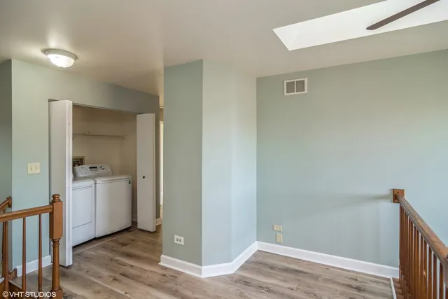 a view of an empty room with closet and wooden floor