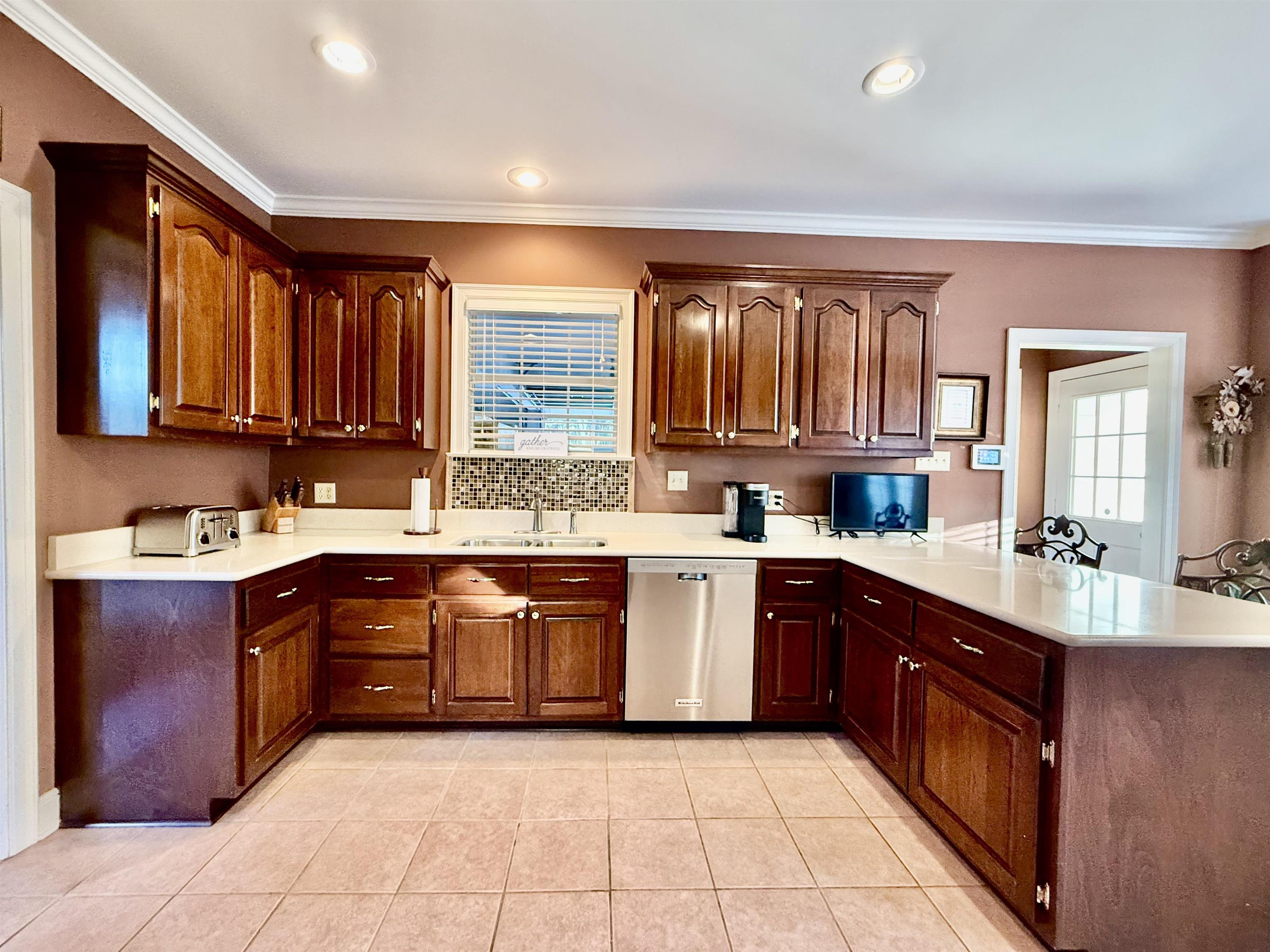 705 Old Solomon Mill Road Somerville, TN 38068 - Photo 15 of 40 a large kitchen with granite countertop a sink dishwasher stove and cabinets