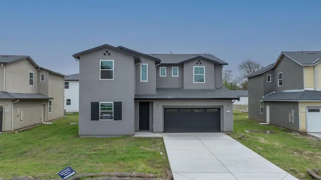 a front view of a house with a yard and garage