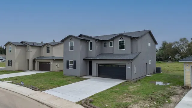 a front view of a house with a yard and garage