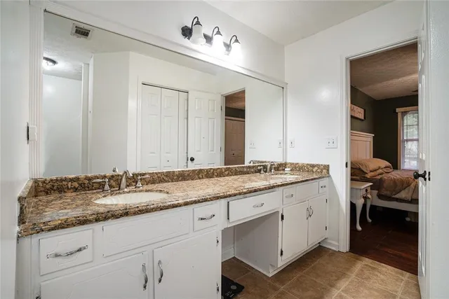 a bathroom with a granite countertop sink double and mirror