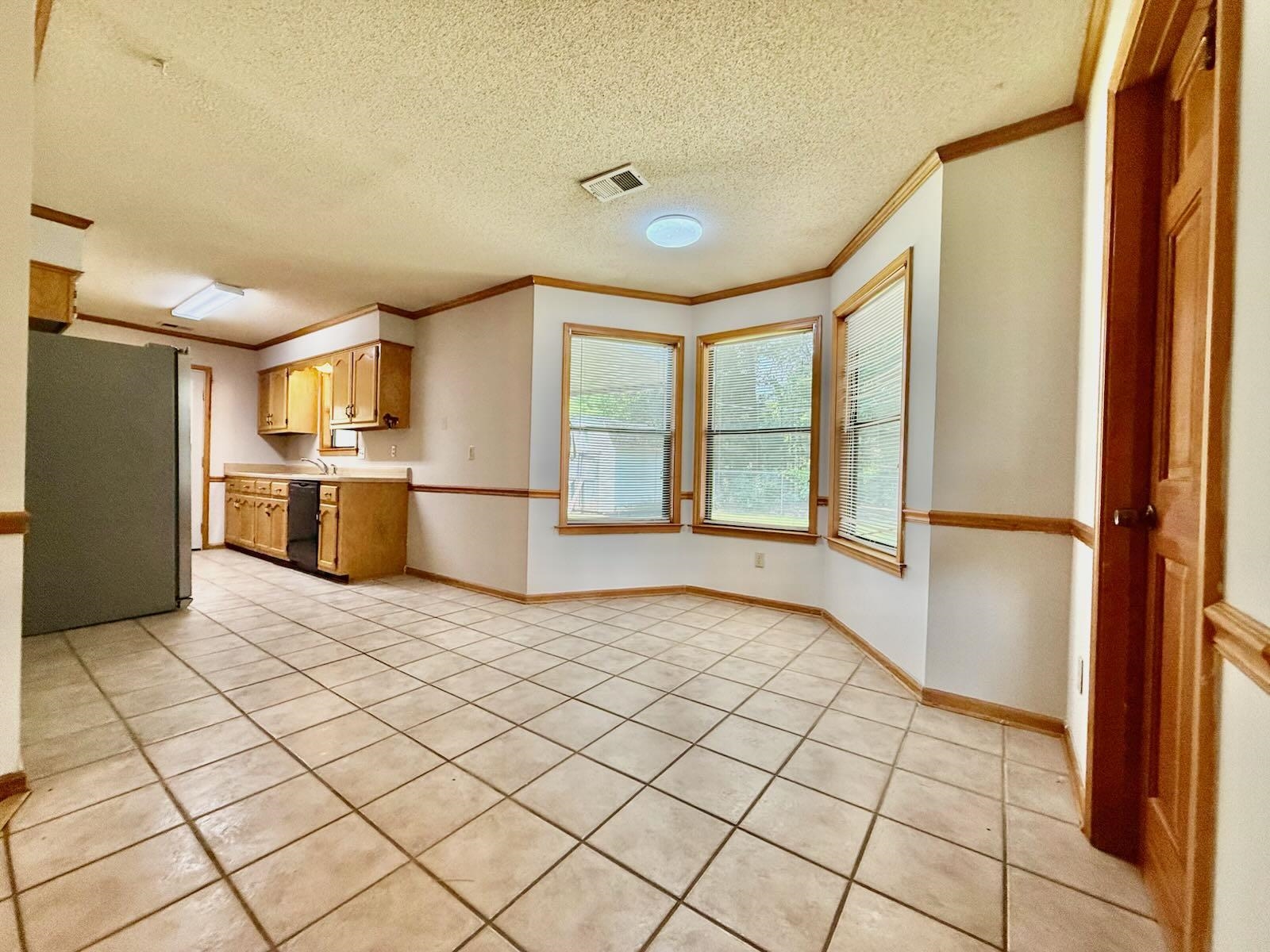 2151 Bartlett Road Memphis, TN 38134 - Photo 8 of 27 Kitchen featuring freestanding refrigerator, light countertops, crown molding, light tile patterned flooring, and dishwasher