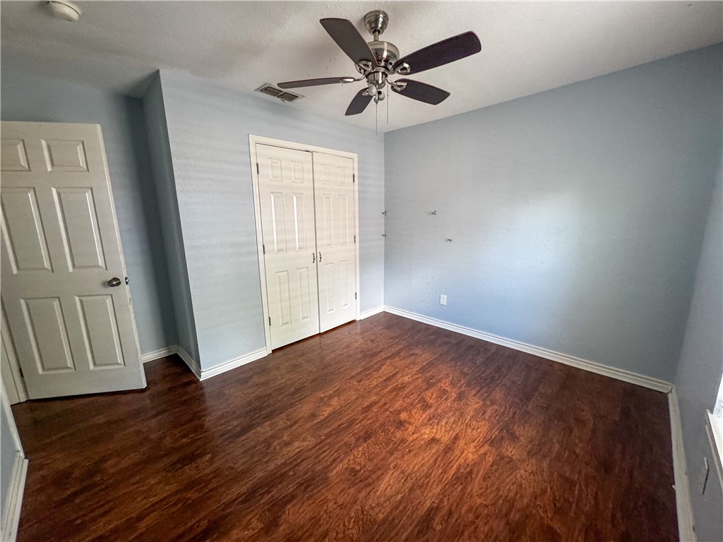 702 Jefferson Street Alice, TX 78332 - Photo 15 of 38 an empty room with wooden floor and windows