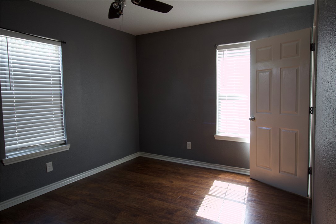 702 Jefferson Street Alice, TX 78332 - Photo 20 of 38 an empty room with wooden floor and windows