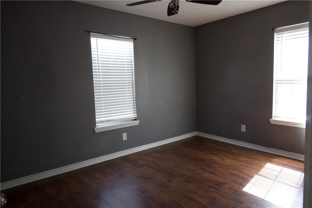 702 Jefferson Street Alice, TX 78332 - Photo 21 of 38 an empty room with wooden floor and windows