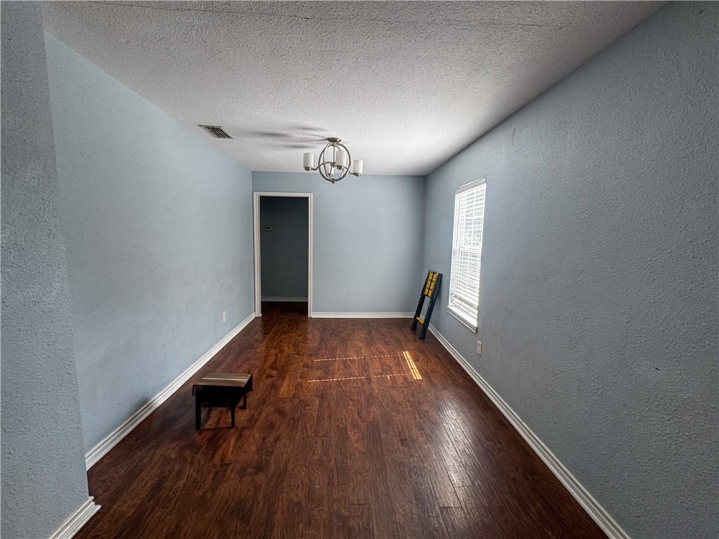 702 Jefferson Street Alice, TX 78332 - Photo 23 of 38 wooden floor in an empty room with a window