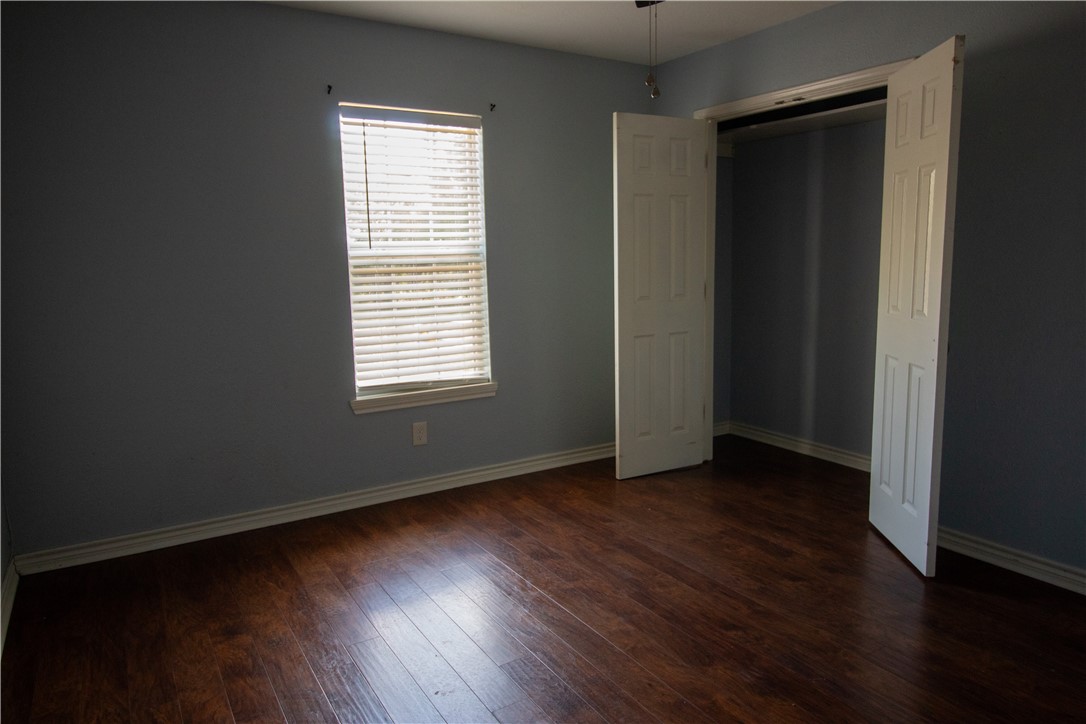 702 Jefferson Street Alice, TX 78332 - Photo 27 of 38 an empty room with wooden floor and windows