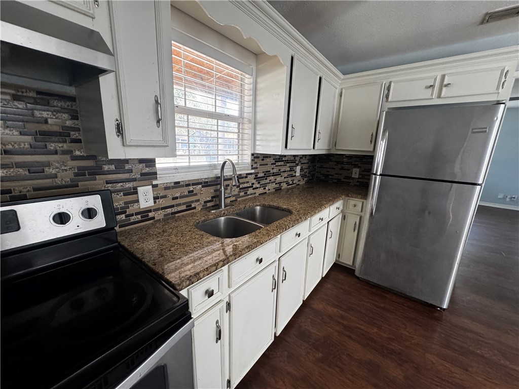 702 Jefferson Street Alice, TX 78332 - Photo 8 of 38 a kitchen with granite countertop a sink stove and refrigerator