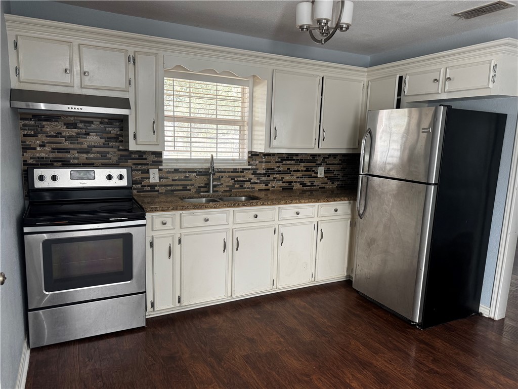 702 Jefferson Street Alice, TX 78332 - Photo 9 of 38 a kitchen with a refrigerator sink and cabinets