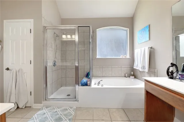 a bathroom with a tub a sink and mirror