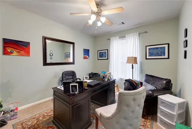 a living room with furniture and paintings on the wall