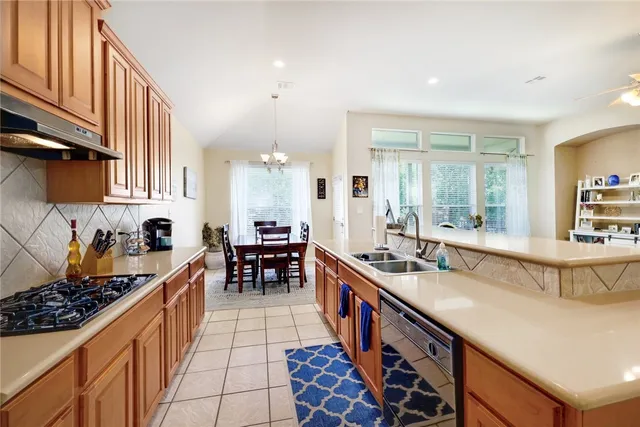 a kitchen with stainless steel appliances granite countertop a stove a sink and a refrigerator