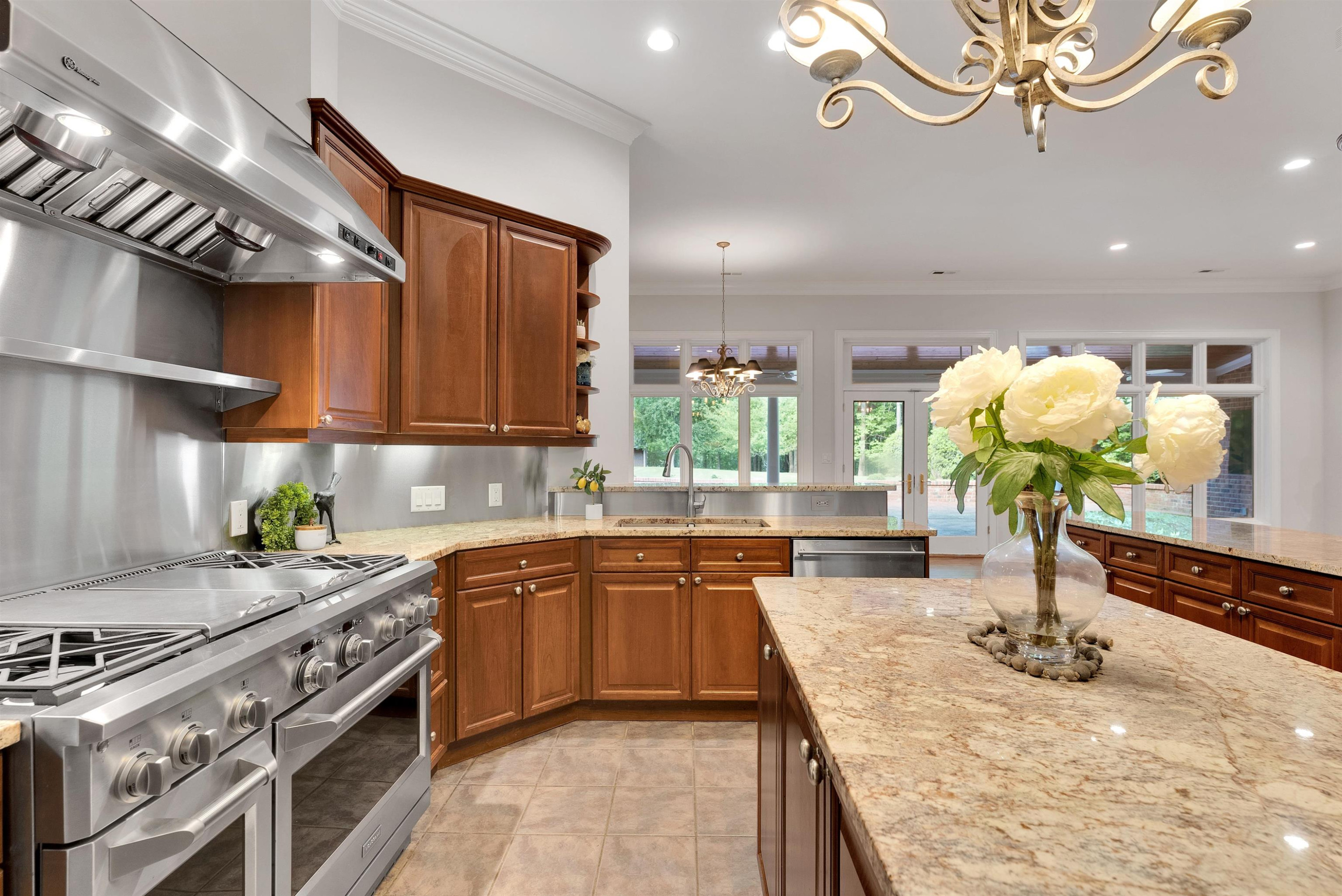 5204 Strathmore Drive Raleigh, NC 27613 - Photo 17 of 32 a kitchen with kitchen island granite countertop a sink stainless steel appliances and cabinets