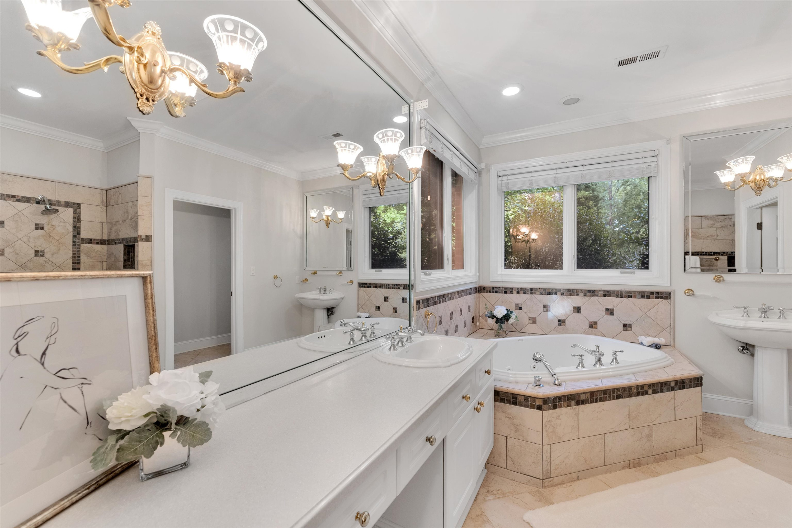 5204 Strathmore Drive Raleigh, NC 27613 - Photo 29 of 32 a bathroom with a sink a large mirror and a bathtub