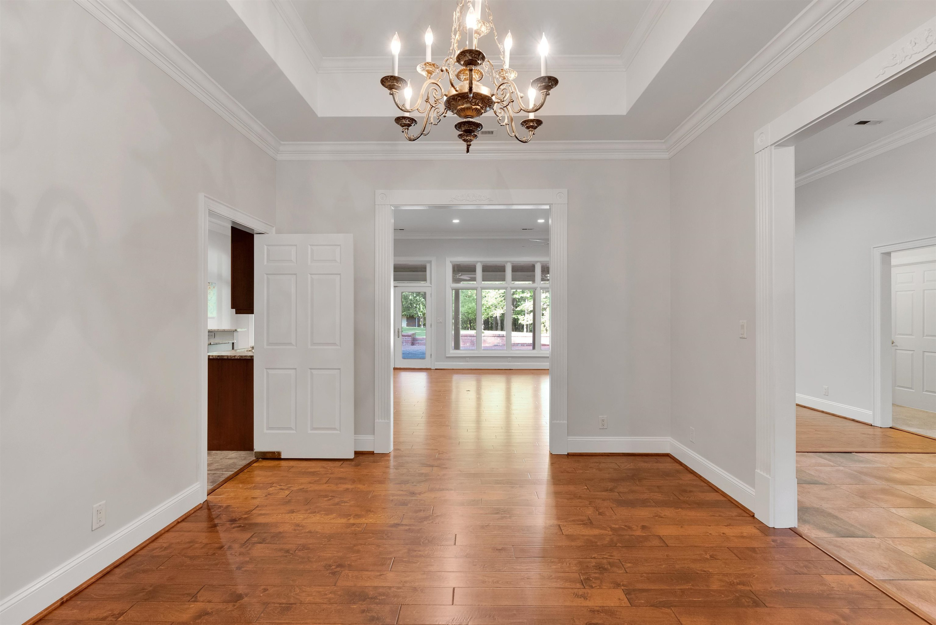 5204 Strathmore Drive Raleigh, NC 27613 - Photo 6 of 32 a view of an empty room with wooden floor and a window