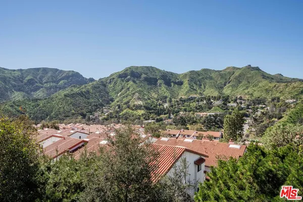 an aerial view of house with yard and mountain view in back