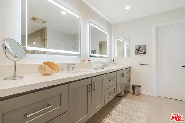 a bathroom with double sink and a mirror
