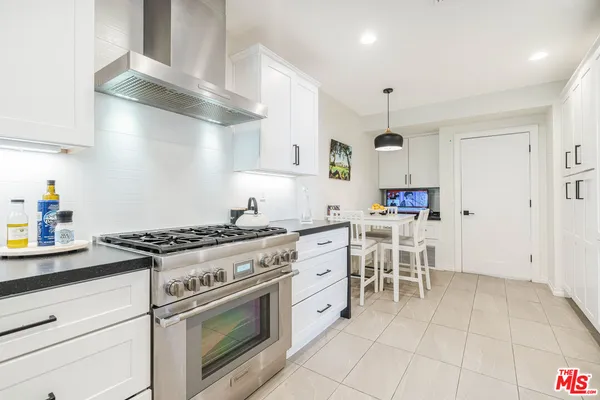 a kitchen with cabinets and chairs