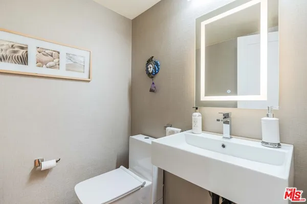 a bathroom with a sink mirror and toilet