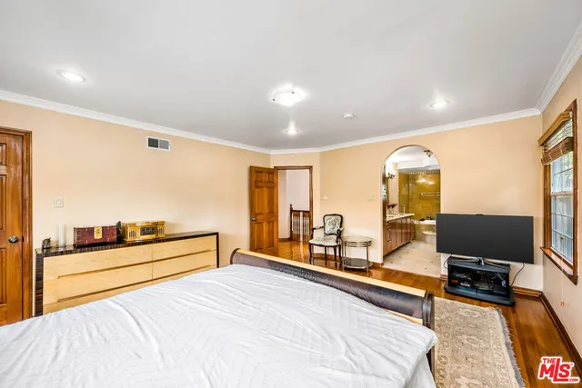 a spacious bedroom with a bed and glass windows