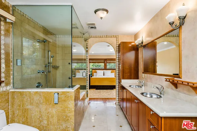 a bathroom with a tub sink shower and mirror