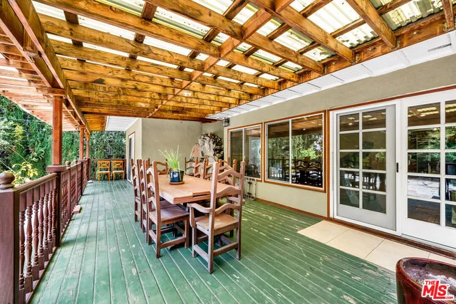 a dining room with wooden floor and balcony