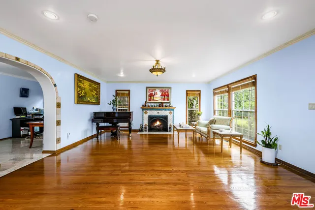 a living room with furniture large window and kitchen view