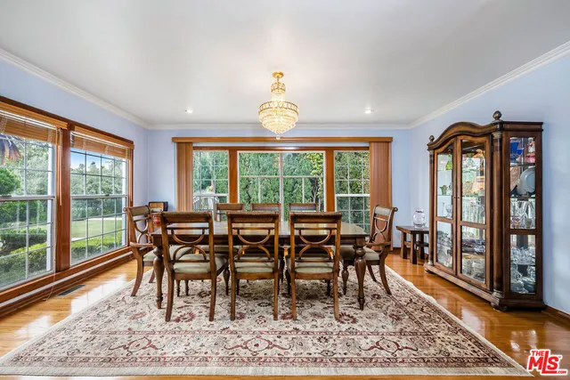 a dining room with wooden floor and a rug