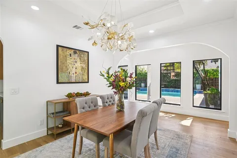 a dining room with furniture potted plants and wooden floor