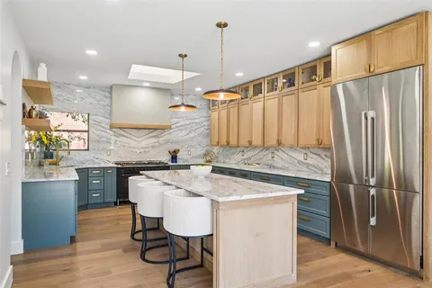 a kitchen with kitchen island a counter top space appliances and cabinets