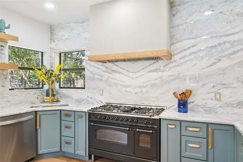 a kitchen with stainless steel appliances a stove and a sink