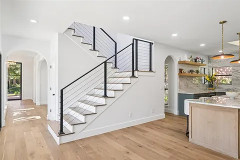 a view of entryway and kitchen with wooden floor