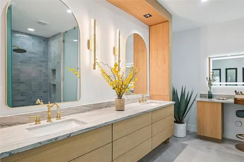 a bathroom with a double vanity sink a mirror and a shower
