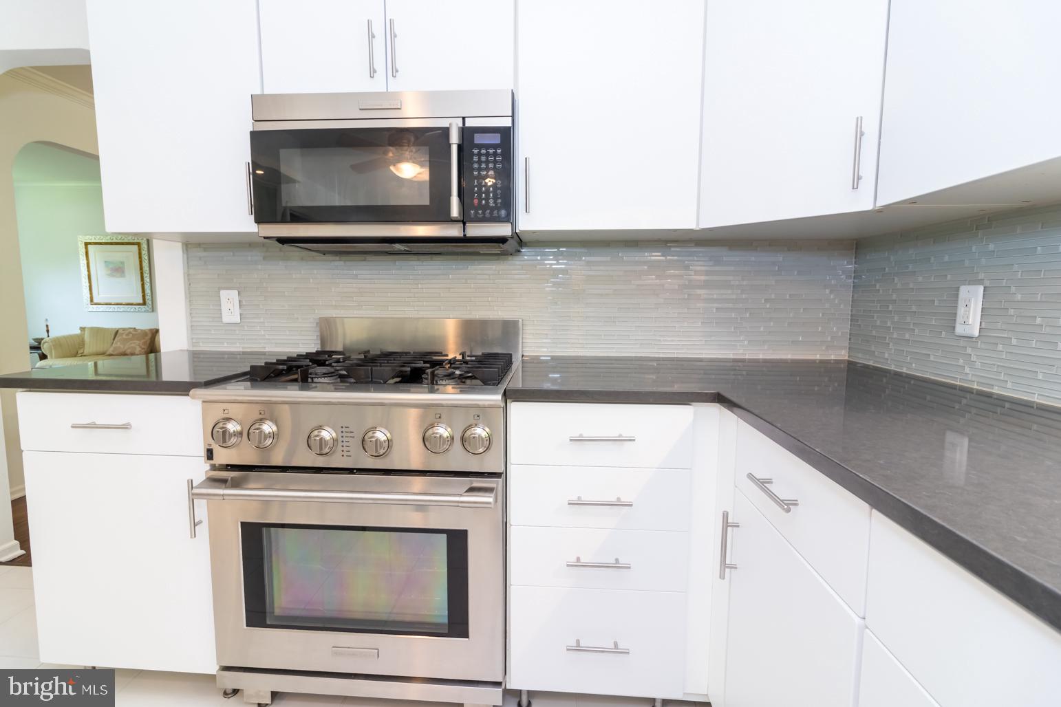 59 Tindall Road Trenton, NJ 08691 - Photo 20 of 76 a kitchen with stainless steel appliances granite countertop white cabinets and a stove top oven