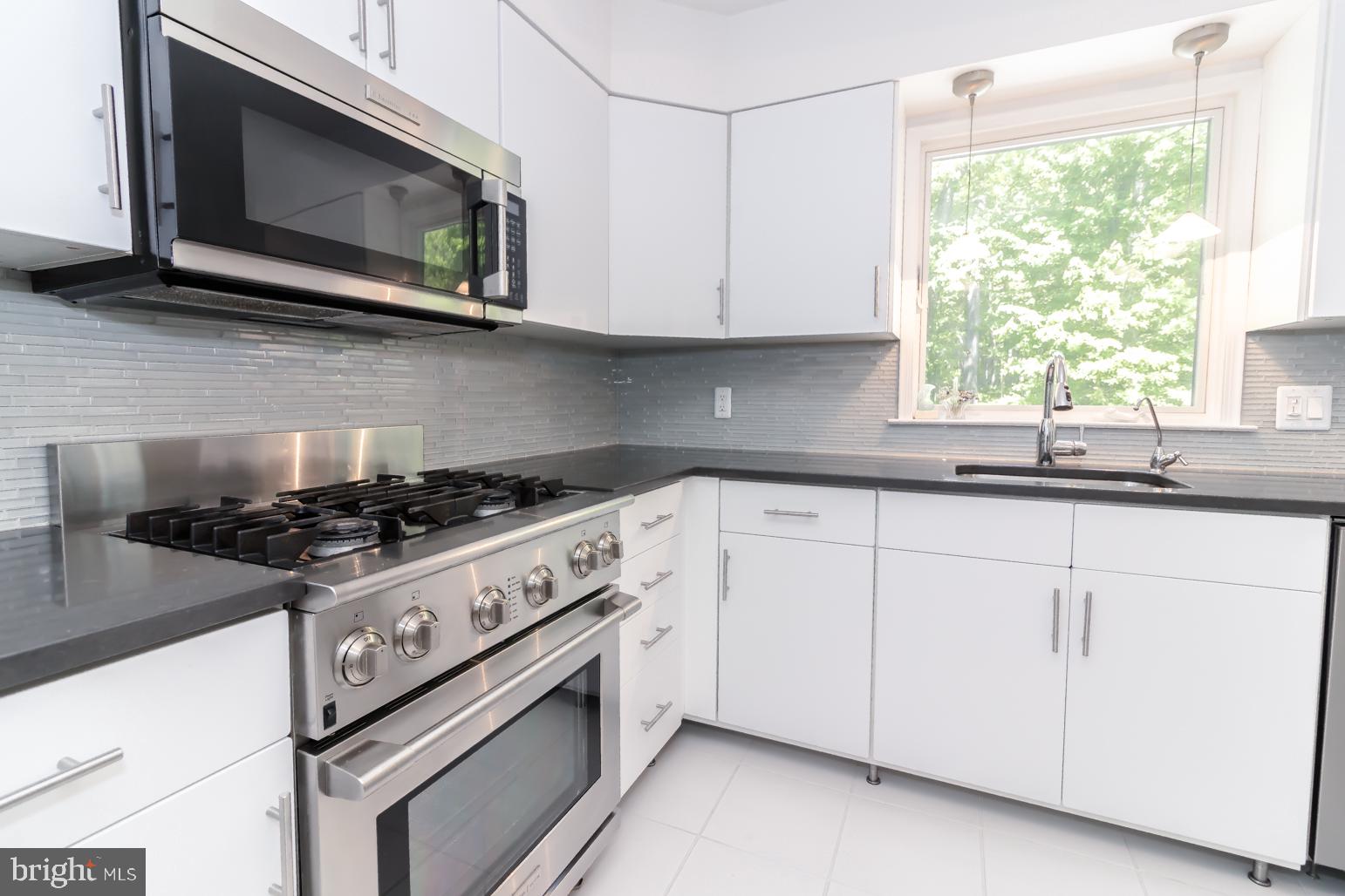 59 Tindall Road Trenton, NJ 08691 - Photo 21 of 76 a kitchen with stainless steel appliances granite countertop white cabinets a window and a sink