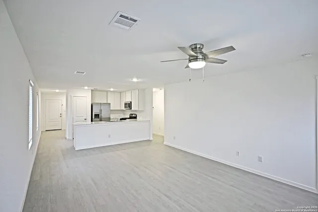 a living room with kitchen island furniture and a ceiling fan