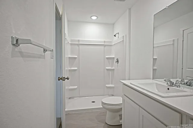 a bathroom with a sink a toilet and shower