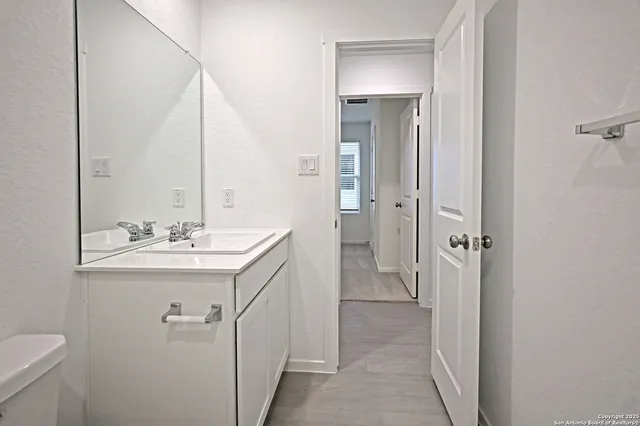 a bathroom with a sink and mirror with toilet