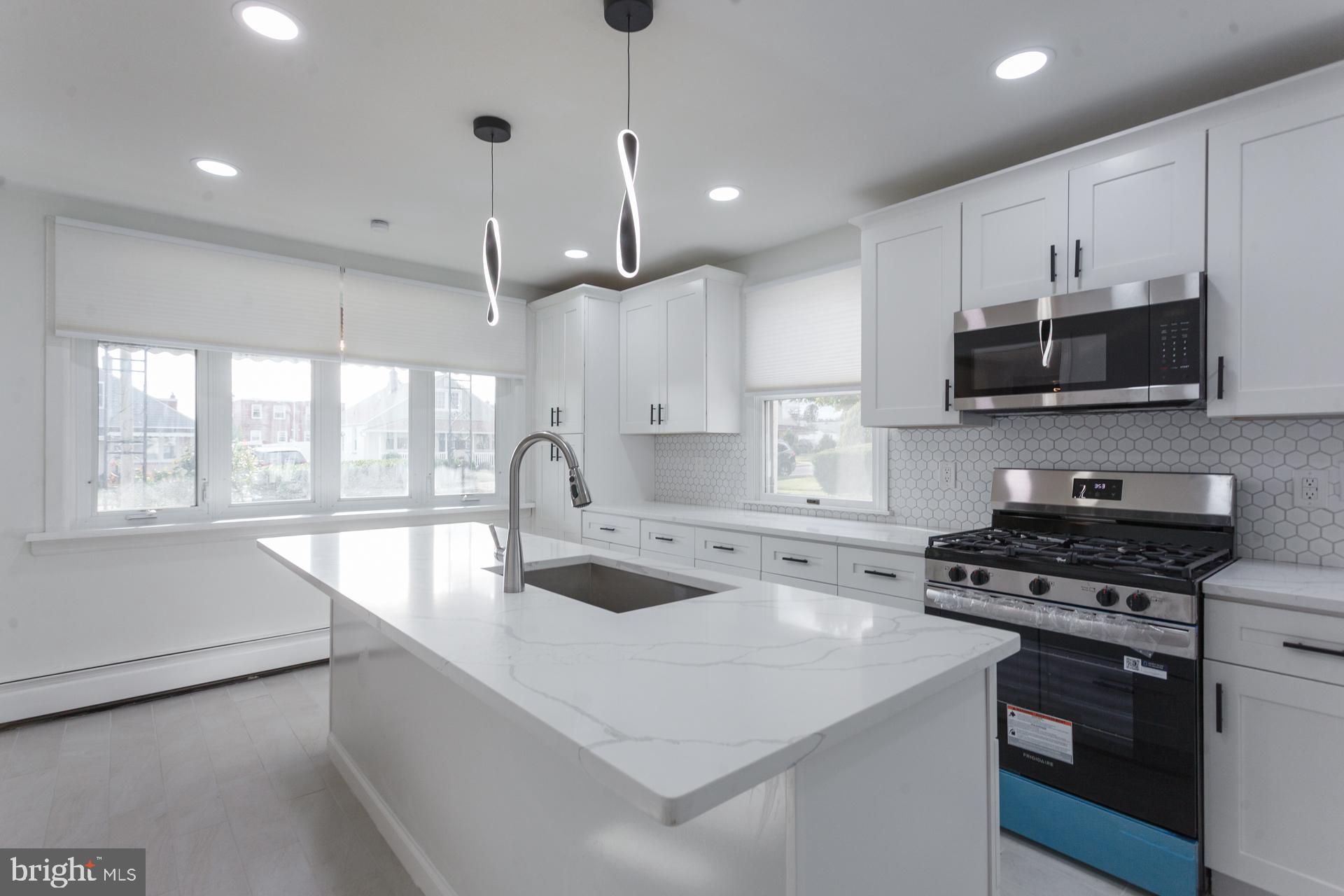 1007 Ripley Street Philadelphia, PA 19111 - Photo 12 of 27 a kitchen with stainless steel appliances a stove sink microwave and cabinets