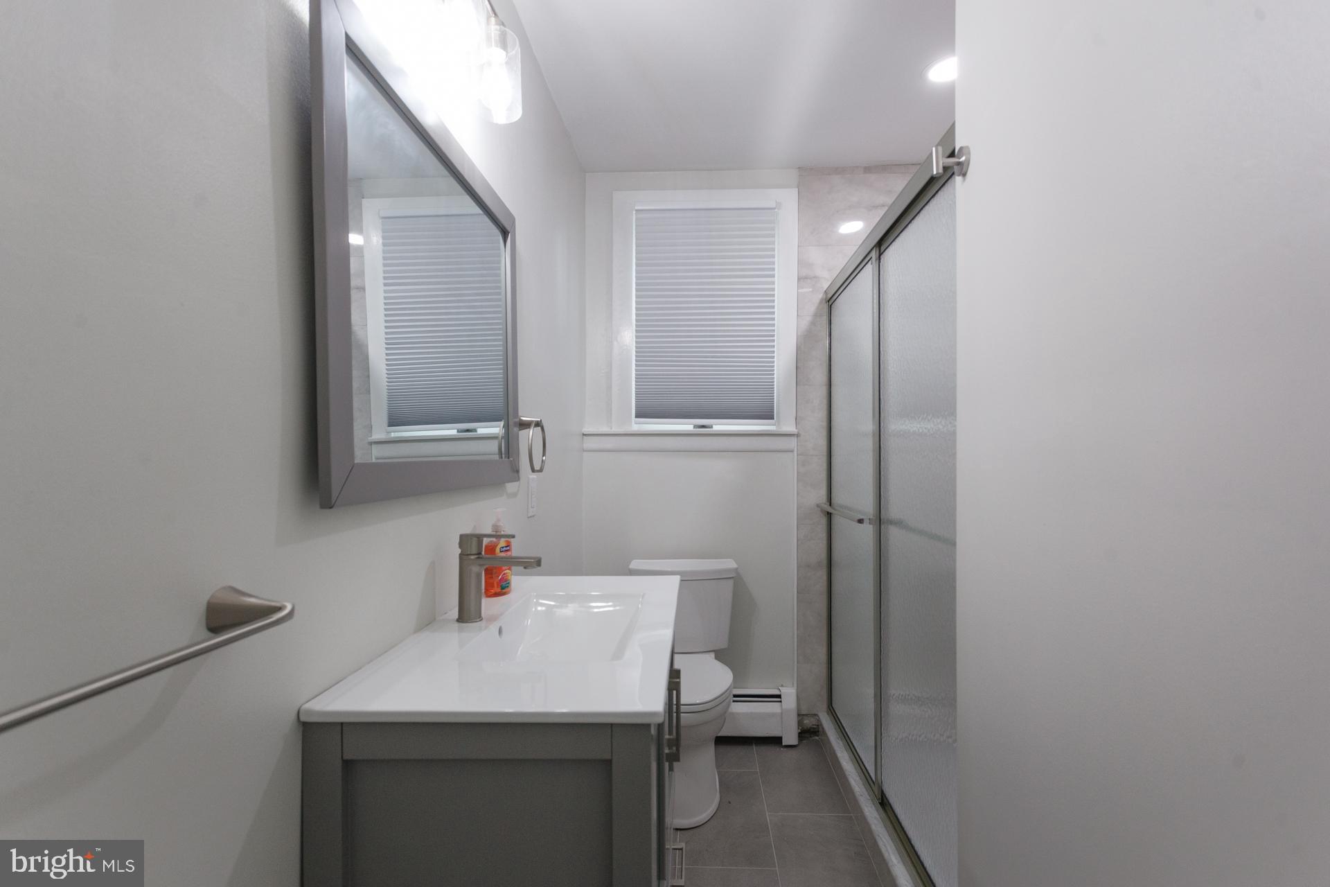 1007 Ripley Street Philadelphia, PA 19111 - Photo 14 of 27 a bathroom with a sink toilet and a mirror