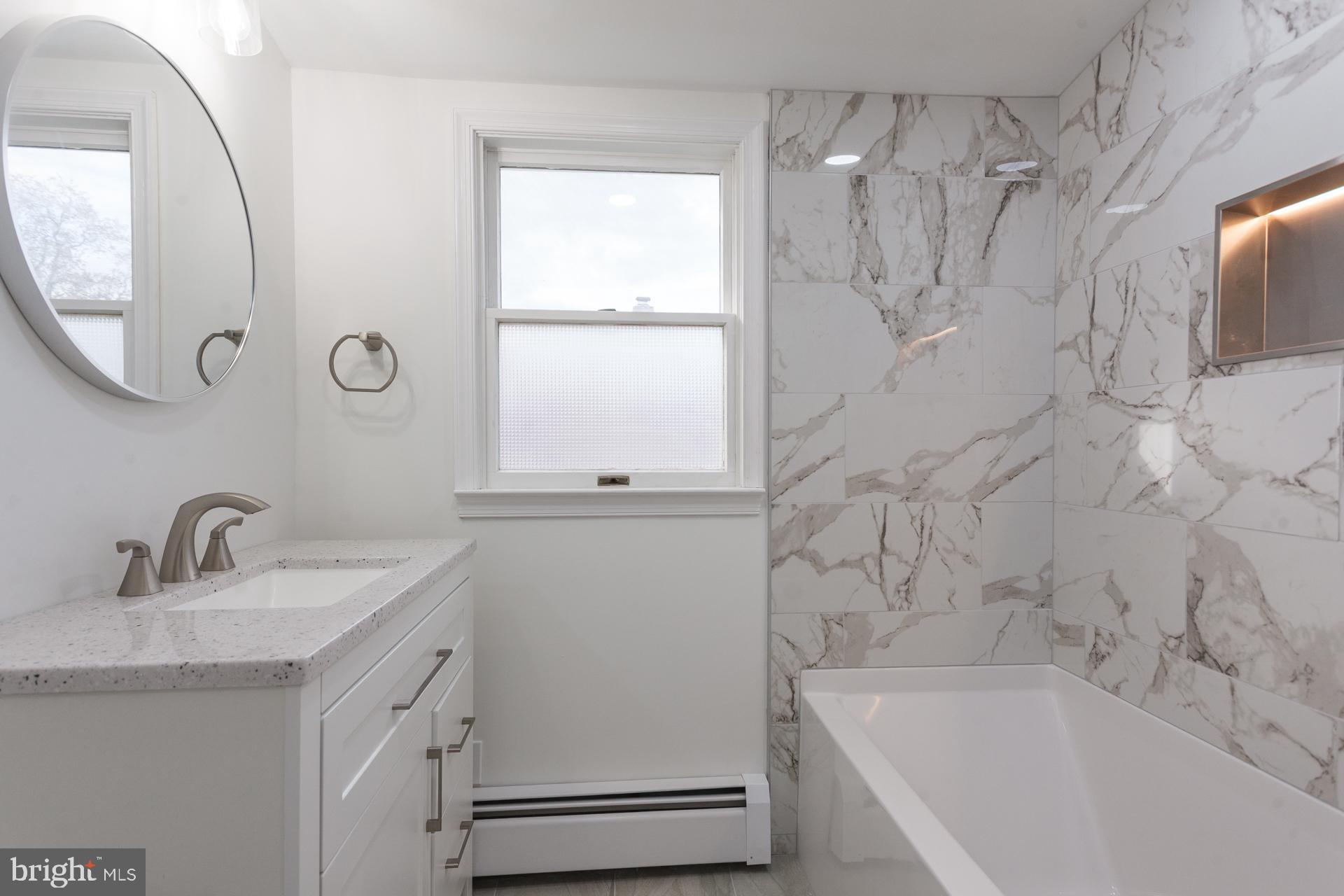 1007 Ripley Street Philadelphia, PA 19111 - Photo 19 of 27 a bathroom with a granite countertop sink a mirror and a bathtub