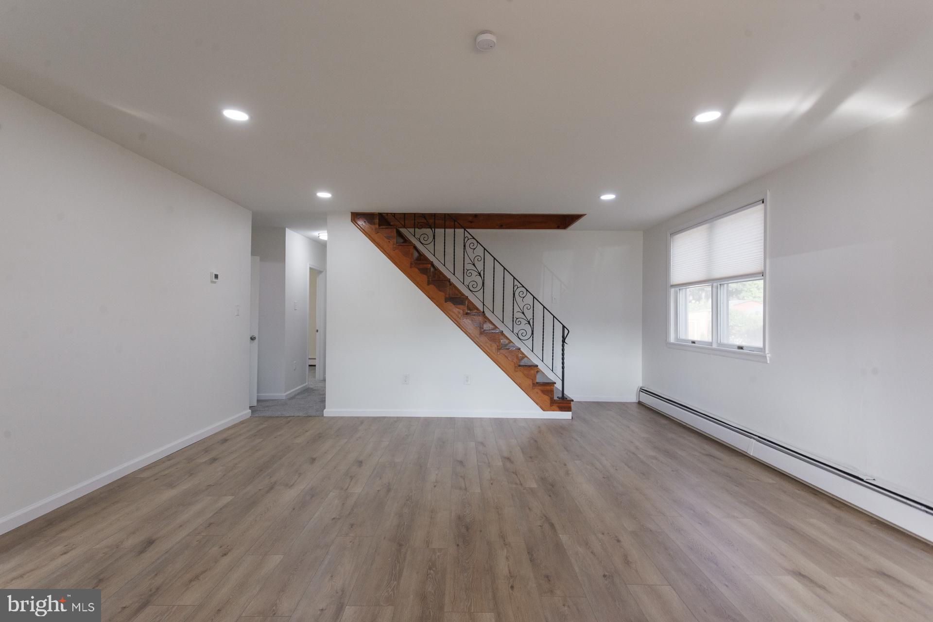 1007 Ripley Street Philadelphia, PA 19111 - Photo 6 of 27 a view of an empty room with wooden floor and stairs